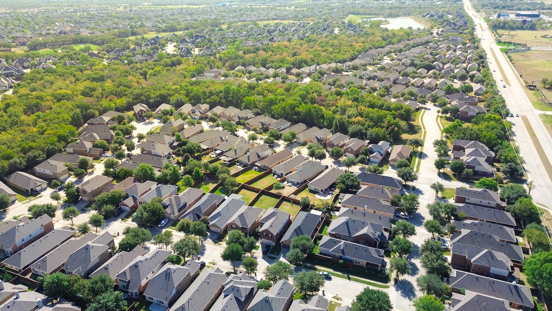 Farm to Market Road 407 fast growing residential area in Argyle and Bartonville, Denton County, Texas, new development two story suburban house solar roofing, lush green belt urban forest, aerial